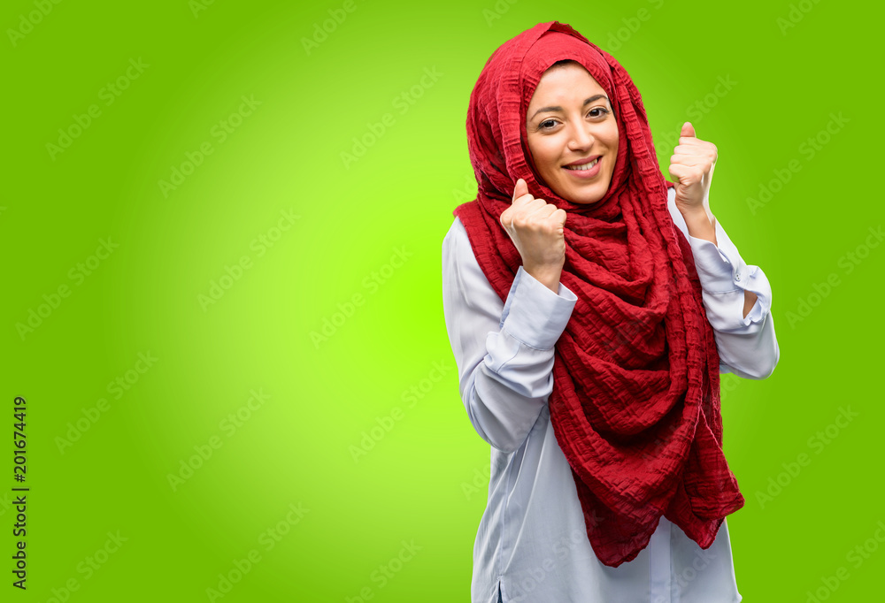 Young arab woman wearing hijab happy and surprised cheering expressing wow gesture Young arab woman wearing hijab happy and surprised cheering expressing wow gesture