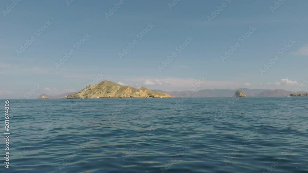 Exotic view of tropical sea with blue water and clear sky near Komodo Island from a boat moving forward, East Nusa Tenggara, Indonesia Exotic view of tropical sea with blue water and clear sky near Komodo Island from a boat moving forward, East Nusa Tenggara, Indonesia