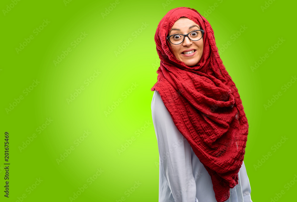 Young arab woman wearing hijab confident and happy with a big crazy smile laughing Young arab woman wearing hijab confident and happy with a big crazy smile laughing