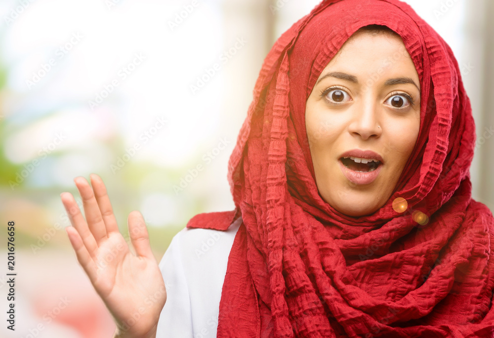 Young arab woman wearing hijab happy and surprised cheering expressing wow gesture Young arab woman wearing hijab happy and surprised cheering expressing wow gesture