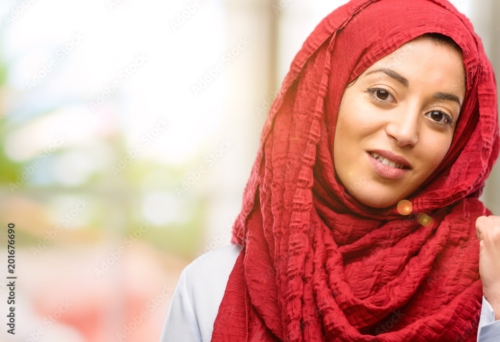 Young arab woman wearing hijab pointing away side with his finger Young arab woman wearing hijab pointing away side with his finger