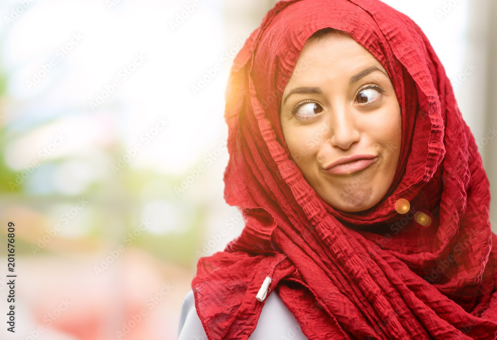 Young arab woman wearing hijab making funny face fooling Young arab woman wearing hijab making funny face fooling