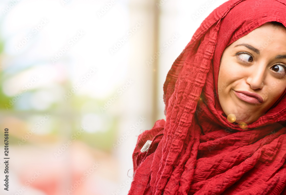 Young arab woman wearing hijab making funny face fooling Young arab woman wearing hijab making funny face fooling