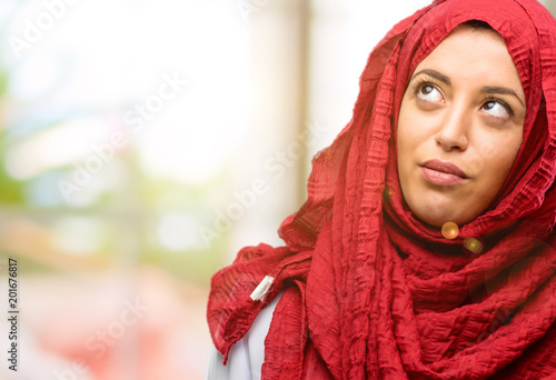 Young arab woman wearing hijab making funny face fooling