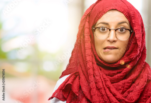 Young arab woman wearing hijab nervous and scared biting lips looking camera with impatient expression, pensive