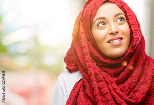 Young arab woman wearing hijab confident and happy with a big natural smile laughing looking up