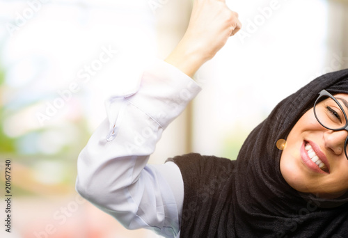 Young arab woman wearing hijab happy and excited celebrating victory expressing big success, power, energy and positive emotions. Celebrates new job joyful