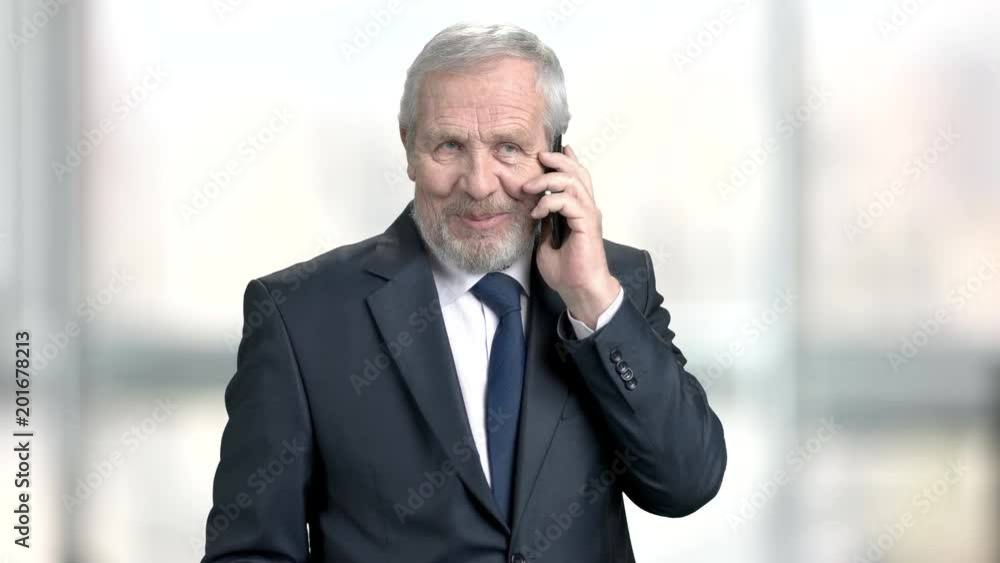 Senior executive with mobile phone. Mature man in formal wear with smartphone on blurred background.