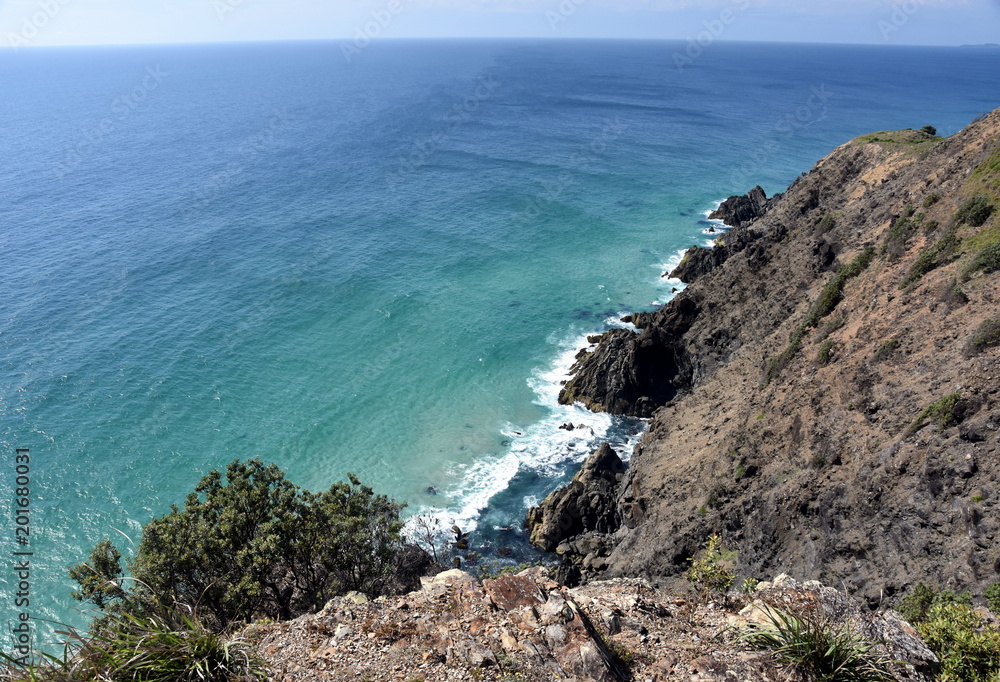 Coastal view and rocks viewed from Cape Byron (NSW, Australia). Waves crashing into rocks.