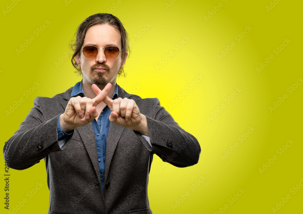 Handsome young man annoyed with bad attitude making stop sign with hand, saying no, expressing security, defense or restriction, maybe pushing Handsome young man annoyed with bad attitude making stop sign with hand, saying no, expressing security, defense or restriction, maybe pushing