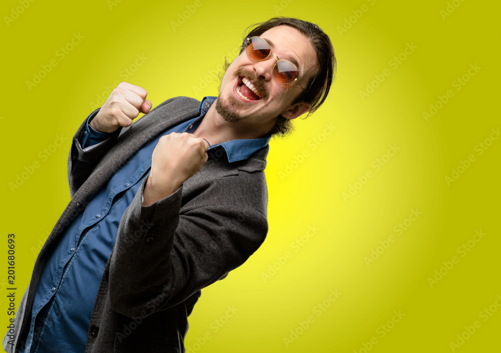 Handsome young man happy and excited expressing winning gesture. Successful and celebrating victory, triumphant Handsome young man happy and excited expressing winning gesture. Successful and celebrating victory, triumphant