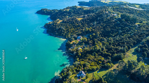 Aerial view on beautiful bay at sunny day with sandy beach and residential houses on the background. Waiheke Island  Auckland  New Zealand