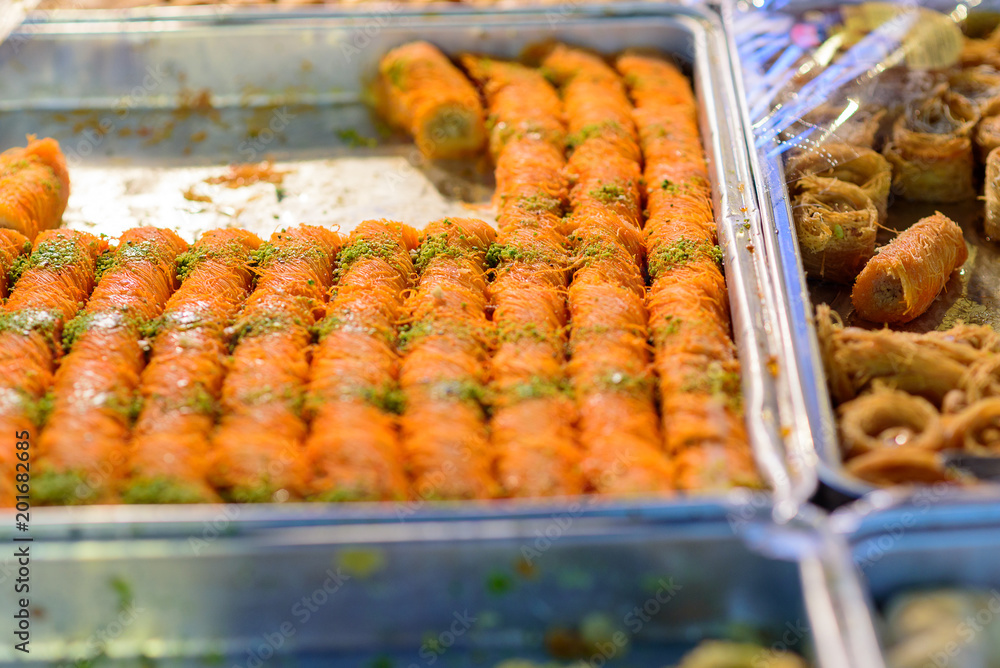 Arabic sweets for celebrate holidays ramadan, iftar,eid on the tray in the market.Selective focus.