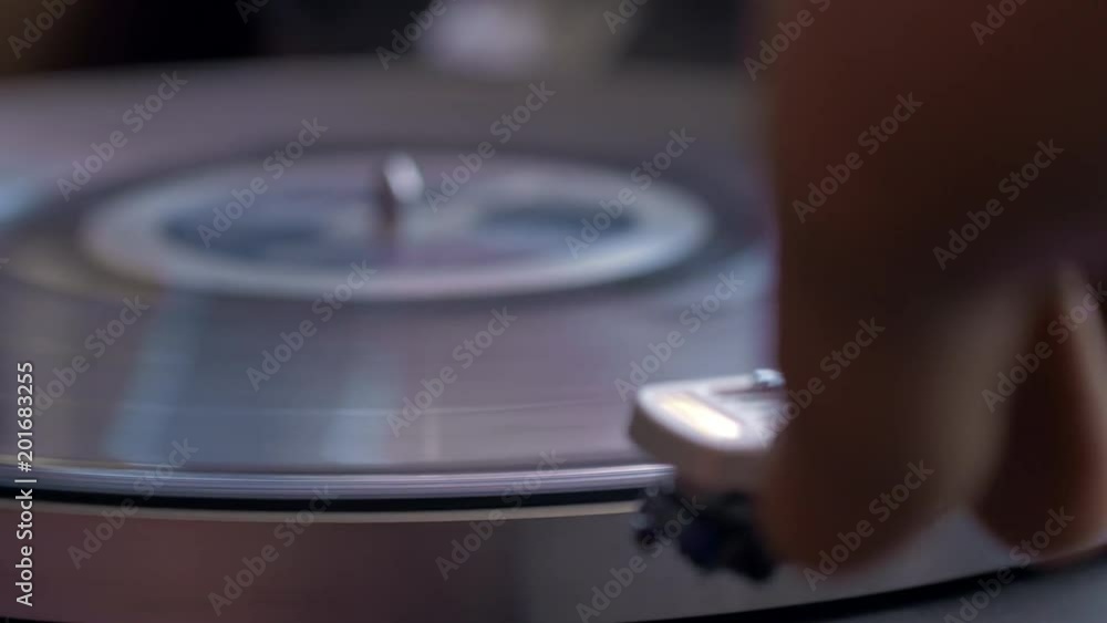 Close up shot of turntable switched on and needle dropped onto record Close up shot of turntable switched on and needle dropped onto record
