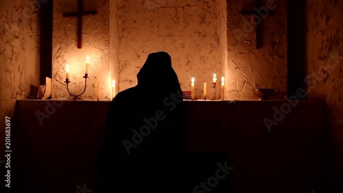 The monk walks the dark room to the altar