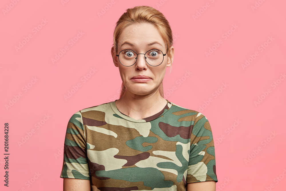 Portrait of beautiful young Caucasian female model stands over pink background, has shocked expression, doesn`t believe in success, sees something unbelievable. People and human emotions concept Portrait of beautiful young Caucasian female model stands over pink background, has shocked expression, doesn`t believe in success, sees something unbelievable. People and human emotions concept