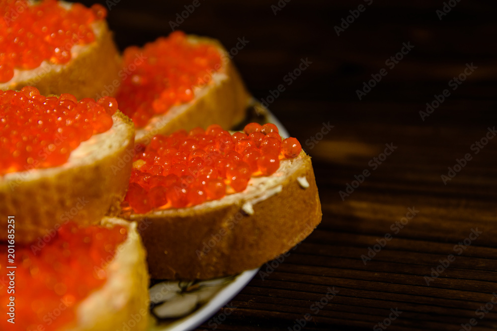 Sandwiches with red caviar on wooden table Sandwiches with red caviar on wooden table