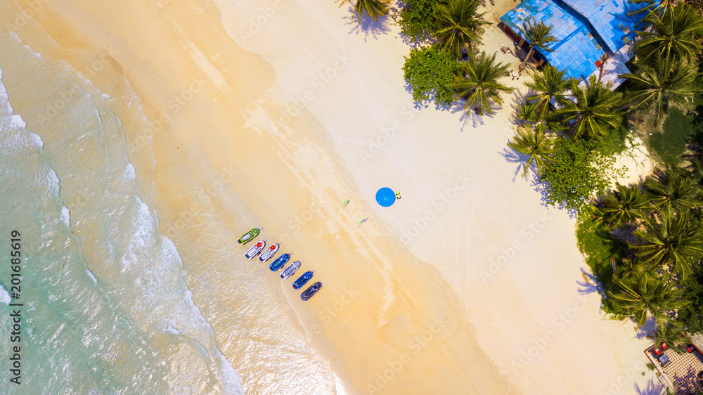 Aerial : Bird eye view of sea waves against the sand beach coast line and  overhead view of a water scooter rental point under blue umbrella foto de  Stock | Adobe Stock