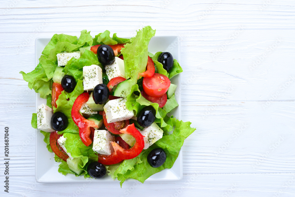 Greek salad on a white wooden background. Space for text or design. Greek salad on a white wooden background. Space for text or design.