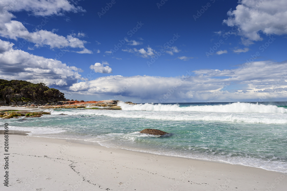 Beautiful sunny summer coast view from Bay Of Fires to blue Tasman Sea with crystal clear water surrounded by red orange colorful shore rocks and white sandy beach, Cosy Corner, Tasmania, Australia