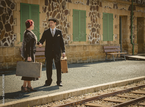 Young couple with vintage suitcases on the train station