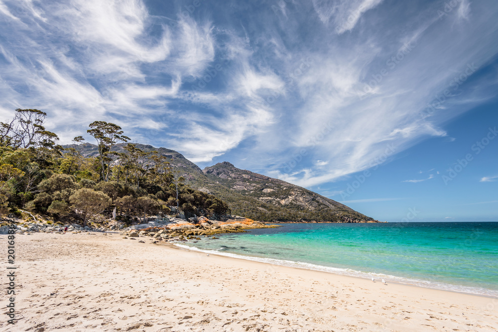 Relaxing amazing view to stunning sandy beach blue turqouise water enjoy swiming warm sunny day with blue sky after hiking on top mountains, Freycinet National Park, Wineglass Bay, Tasmania, Australia