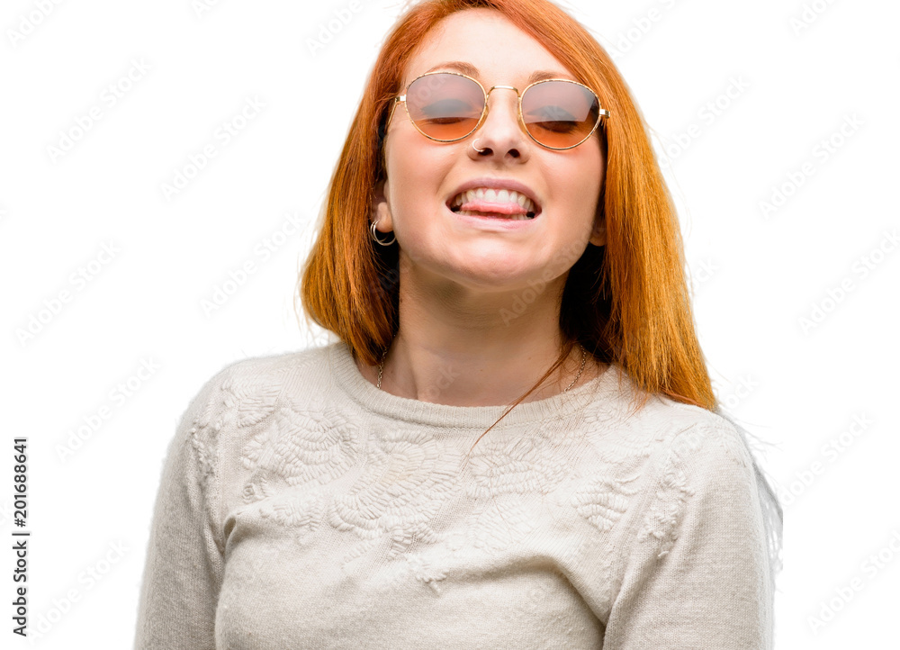 Beautiful young redhead woman sticking out tongue at camera at sign of disobedience, protest and disrespect isolated over white background Beautiful young redhead woman sticking out tongue at camera at sign of disobedience, protest and disrespect isolated over white background
