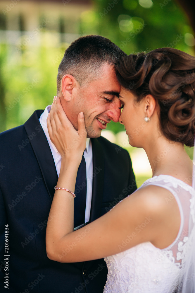 Naklejka premium Beautiful couple walking in the park in their wedding day. Sunny weather