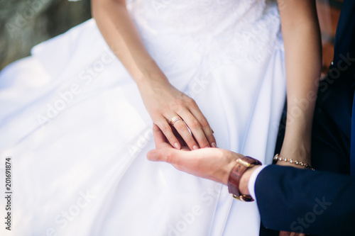 Young couple, bride and groom walking and enjoying their wedding day. Sunshine. Summer