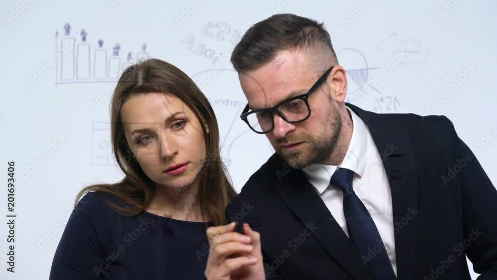 Man and woman discuss the business strategy for success in a modern glass office Man and woman discuss the business strategy for success in a modern glass office