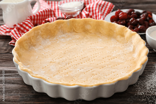 фотографія Baking pan with unbaked crust for cherry pie on kitchen table