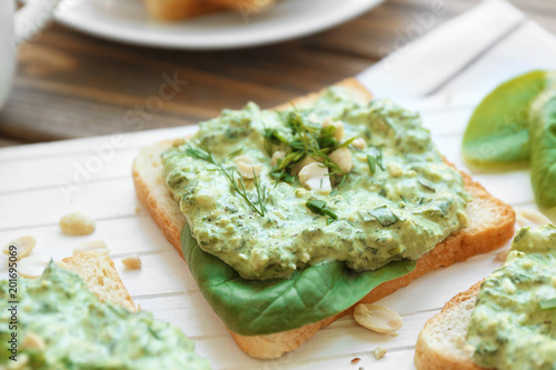 Toast with tasty spinach sauce on table