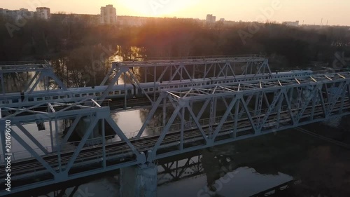 View from the height of the railway bridge on which the train is passing at sunset photo