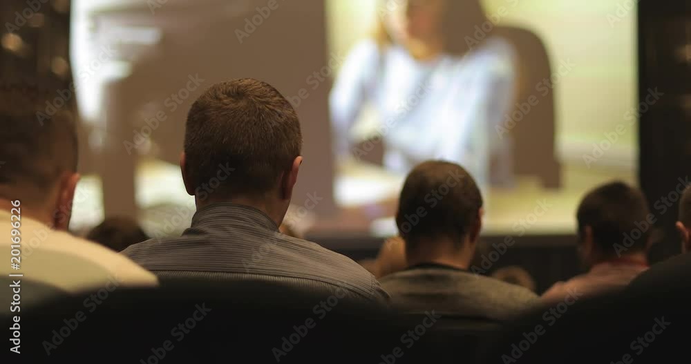 Unrecognizable people at the cinema or at the conference are looking at the screen. Unrecognizable people at the cinema or at the conference are looking at the screen.