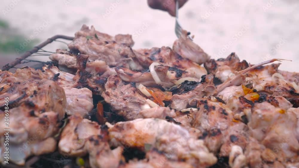 Closeup sunny outdoor Chef turns the meat on the grill Closeup sunny outdoor Chef turns the meat on the grill