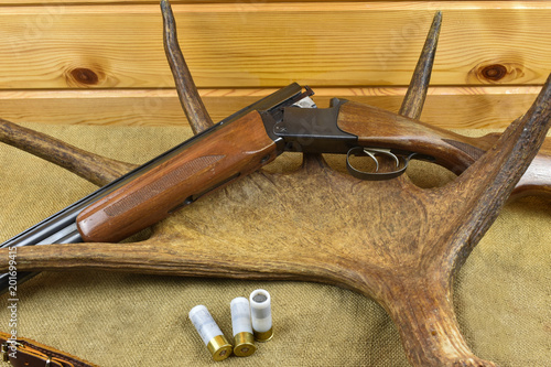 Hunting rifle lies on the horn, next to three cartridges