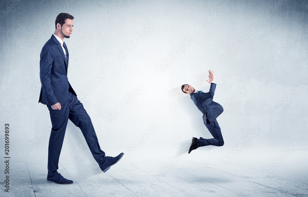 Big businessman kicking small businessman who is flying away with his briefcase on his hand
