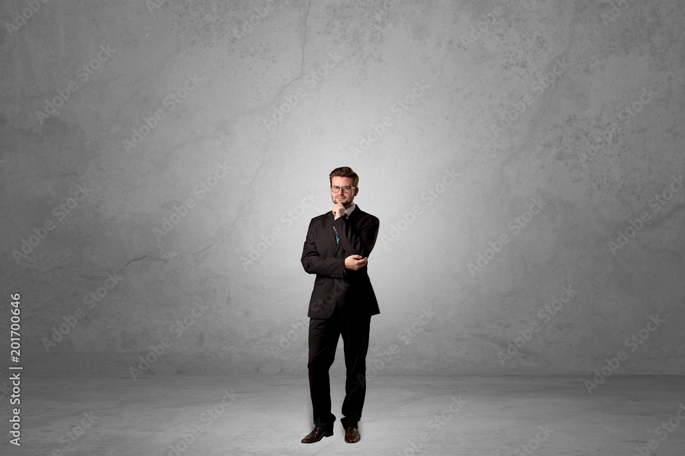 Alone handsome businessman standing in a dark empty room Alone handsome businessman standing in a dark empty room
