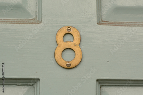 House number 8 sign on door painted green photo