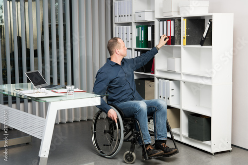 disabled business in wheelchair taking a folder