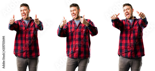 Young man stand happy and positive with thumbs up approving with a big smile expressing okay gesture isolated over white background, collage composition