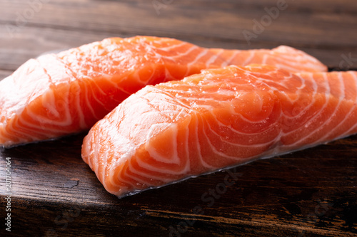 Fresh raw salmon fillet. Old wooden background. Selective focus.