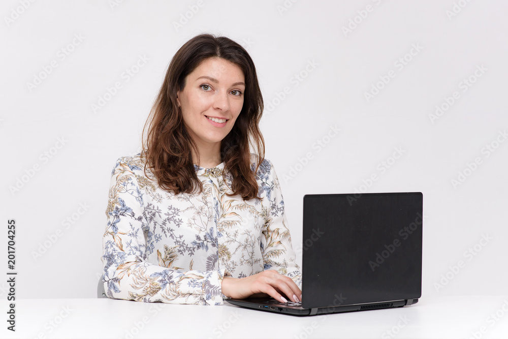 beautiful young girl sitting at the table with a laptop in different poses beautiful young girl sitting at the table with a laptop in different poses