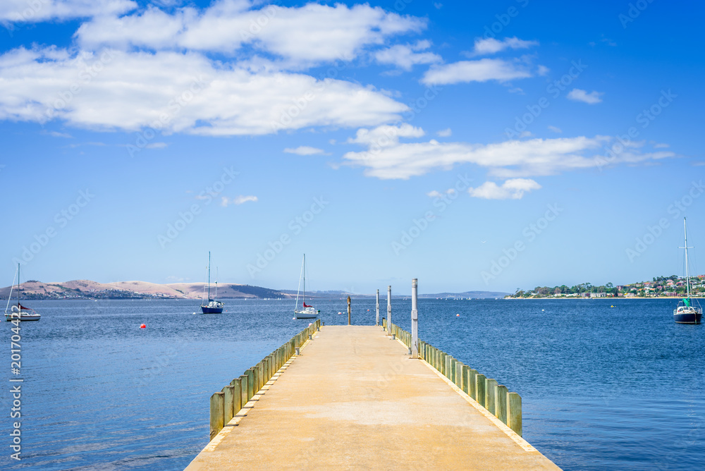 Pretty view to stunning blue water of southern ocean antarctica on warm sunny day with blue sky mountains and some fishing boats yacht cruising capital city, Hobart, Tasmania, Australia - 11-17-20: