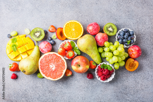 Overhead shoot with fresh assorted fruits and berries on light gray background. Colorful clean and healthy eating. Detox food. Copy space. Top view.