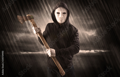 Masked armed poacher in mysterious rainy coastal weather concept 