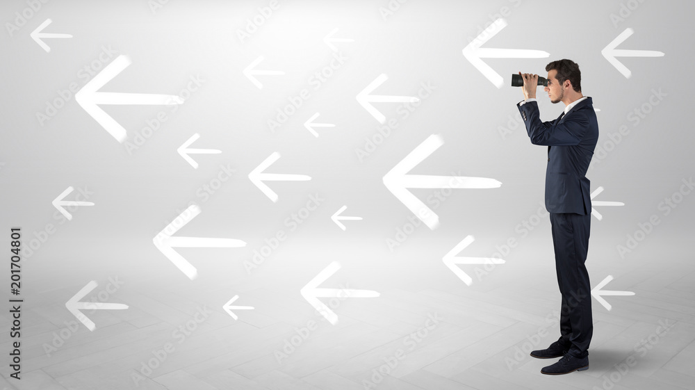 Young businessman standing and looking through binoculars with drawn arrows around
Young businessman standing and looking through binoculars with drawn arrows around