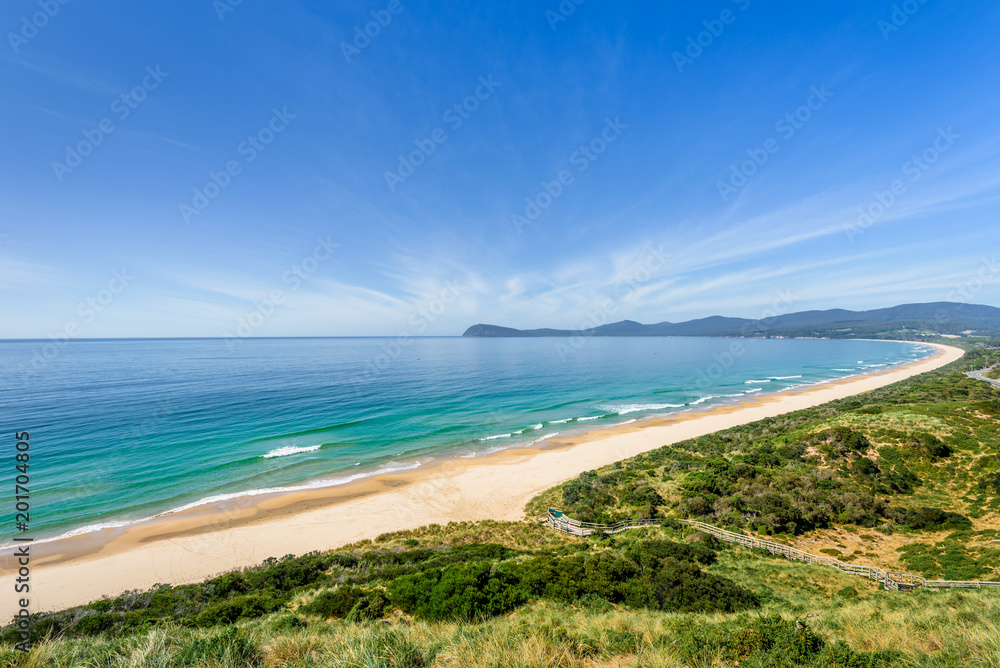 Amazing wooden view point over small green island sandy beach shore with turquoise blue water of southern ocean on a warm sunny blue sky day, The Neck, Bruny Island, Tasmania, Australia - 11-18-2017