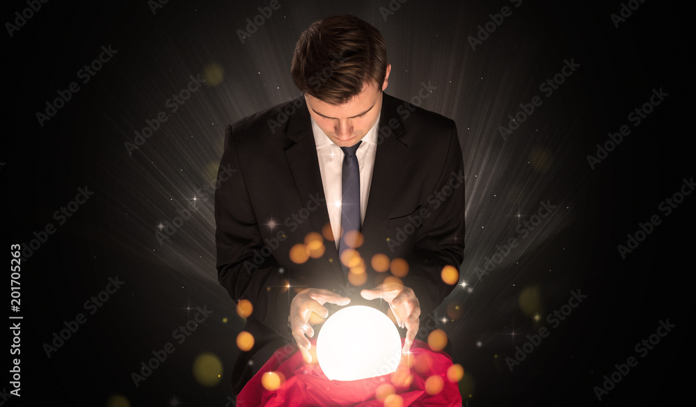 Fototapeta premium Gorgeous businessman sitting with sparkling magic ball in his lap