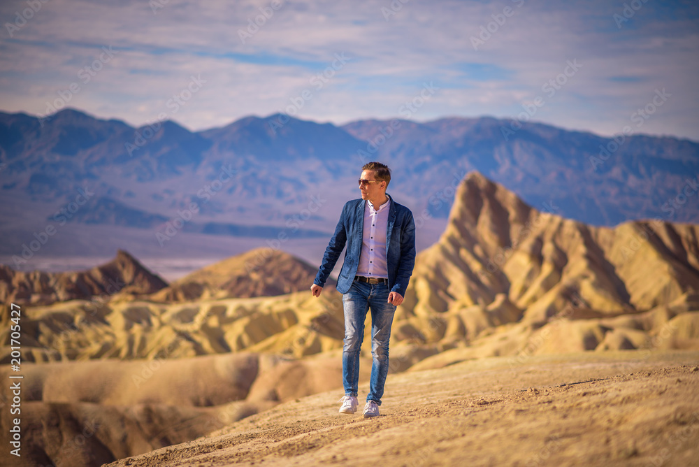 Young man walking alone in the desert of Death Valley